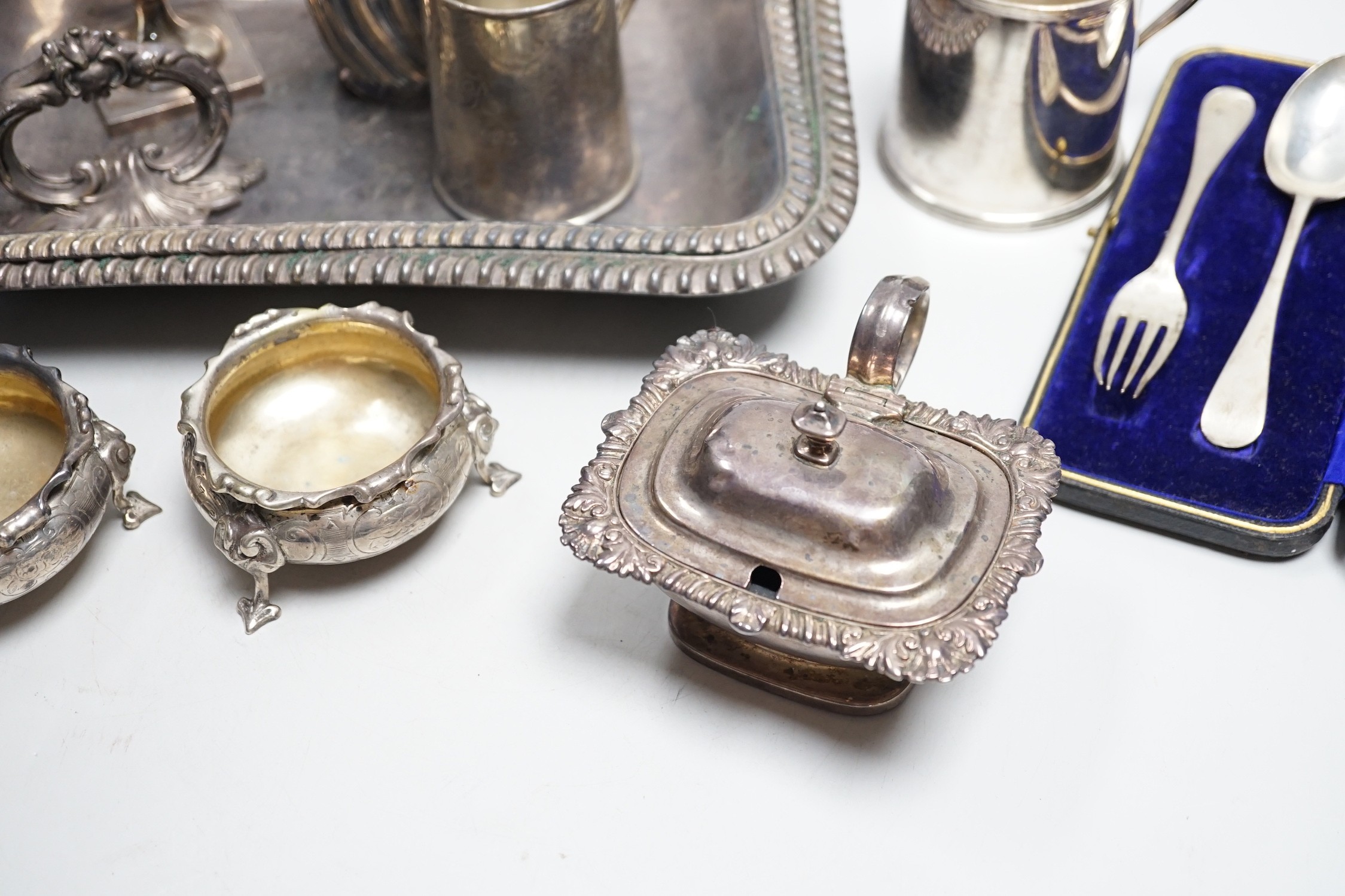 A small collection of English silver to include a pair of Victorian cauldron salts, two small beakers, a cream jug with presentation script, a George IV silver mustard pot with hinged cover, London, 1823 and a boxed chri